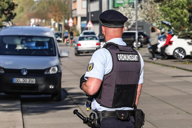 Ein Mitarbeiter des Ordnungsamts kontrolliert ein abgestelltes Fahrzeug.
