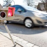 Ein Auto fährt an einem mobilen Blitzer vorbei.