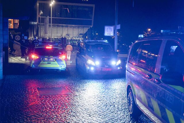 Streifenwagen stehen bei Nacht auf dem Platz Deutschen Einheit in Dortmund.