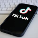 Ein Smartphone mit TikTok Logo auf dem display liegt auf einem Tisch. Symbolbild