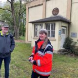 Ein Mann und eine Frau stehen vor einem alten Gebäude auf dem Werksgelände