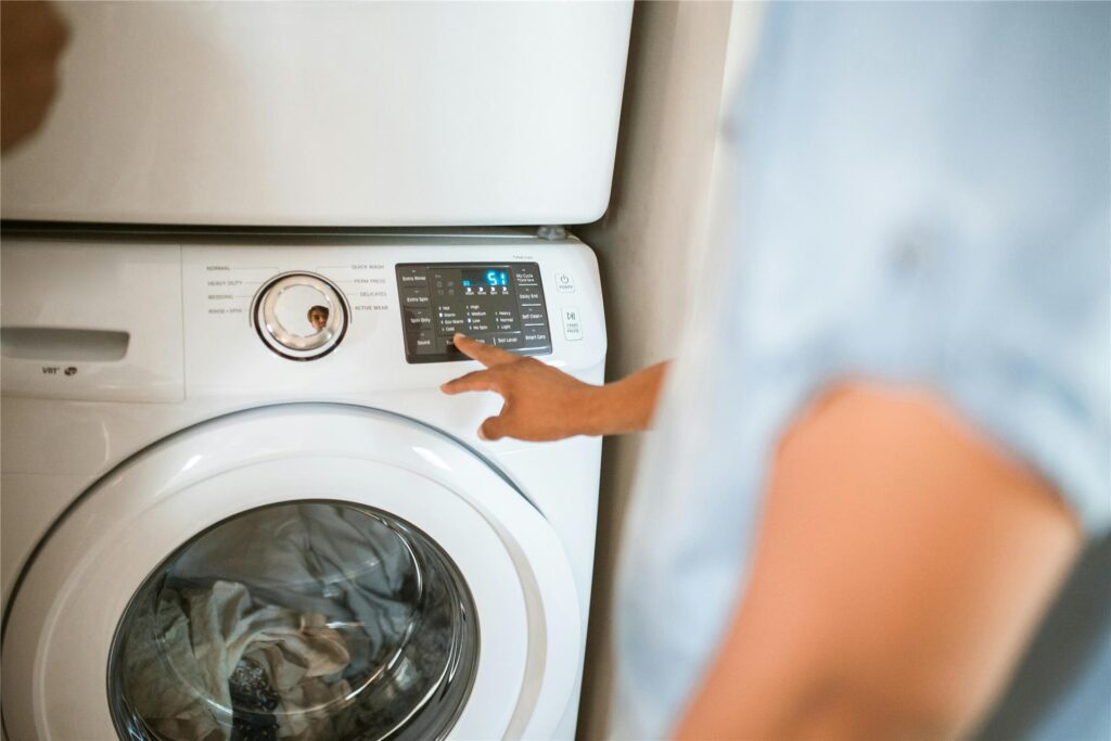 Ein Mann schaltet die Waschmaschine ein. Ein Mann schaltet die Waschmaschine ein.