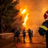 Feuerwehrleute bekämpfen einen Waldbrand, der sich einer Tankstelle nähert, in einem Waldgebiet nördlich von Athen.