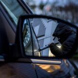 Ein Mann bricht ein Auto auf