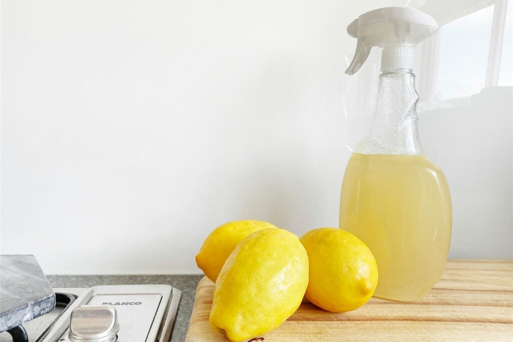 Auf einem Holzbrett liegen Zitronen und daneben steht eine Sprühflasche gefüllt mit Zitronensaft. Auf einem Holzbrett liegen Zitronen und daneben steht eine Sprühflasche gefüllt mit Zitronensaft.