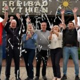 Vorstand des Freibadvereins Sythen jubelt über den 50. Geburtstag vor dem Eingang.