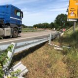 Ein LKW fährt über den Bossendorfer Damm, die Leitplanke ist demoliert.