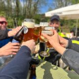 Ein paar Männer sitzen in einem Biergarten in Datteln und stoßen an.