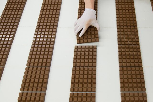 Ein Mitarbeiter des Schokoladenherstellers Ritter Sport kontrolliert Schokoladentafeln.