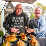 Ein Paar steht vor einem Tisch mit diversen Street-Food-Speisen auf dem Rathausplatz in Recklinghausen.