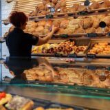 Eine Mitarbeiterin räumt Brot in die Auslage einer Bäckerei.