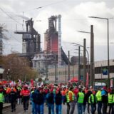 Teilnehmer einer Kundgebung im Rahmen des bundesweiten Aktionstags für einen Brückenstrompreis laufen vor den Hochhöfen des Werks von Thyssenkrupp.