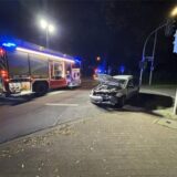 Ein stark demolierter Pkw steht auf der Kreuzung Langenbochumer Straße / Backumer Straße in Herten. Daneben ist ein Einsatzfahrzeug der Hertener Feuerwehr.