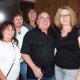 Vier Frauen und ein Mann haben sich für ein Gruppenfoto zusammengestellt und lächeln freundlich in die Kamera.
