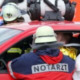 Ein Notarzt hilft einem Fahrer nach einem Unfall.