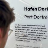 Eine Infotafel am Hauptbahnhof Dortmund informiert über den Hafen. Ein Passant hat darauf provisorisch einen Fehler korrigiert.