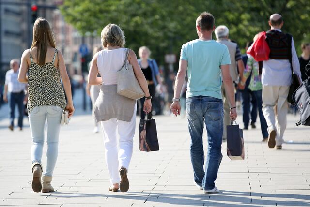 Eine Familie läuft am verkaufsoffenen Sonntag mit Einkaufstüten in der Hand durch die Innenstadt.