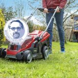 Ein Mann fährt mit einem Rasenmäher durch seinen Garten.