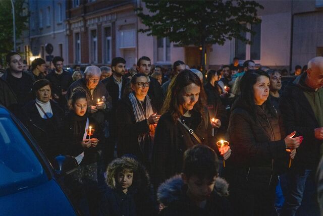Viele Menschen laufen bei einer Prozession mit einer Kerze in der Hand durch eine Straße in Dortmund.