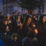 Viele Menschen laufen bei einer Prozession mit einer Kerze in der Hand durch eine Straße in Dortmund.