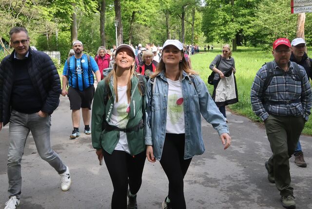 Zwei Frauen führen eine große Wandergruppe an.