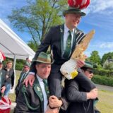 Der neue Schützenkönig der Bürgerschützengilde Suderwich wird auf Schultern getragen. In der Hand hält er den abgeschossenen Holzvogel.