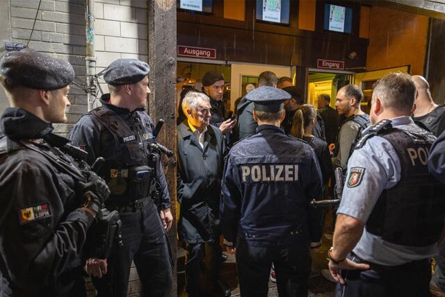 Mehrere Polizisten und NRW-Innenminister Herbert Reul stehen vor einem Lokal in Dortmund.