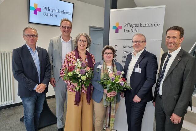 Vier Männer und zwei Frauen stehen vor dem Schild der Pflegeakademie Datteln.