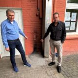 Michael Chasanis und Thorsten Schnelle vor der Brandstelle an der Außenwand der Agora.