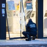 Eine Kriminaltechnikerin kniet vor der zerstörten Bankfiliale.