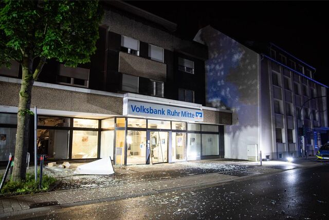 Außenansicht  der zerstörten Bankfiliale, vor der viele Glassplitter liegen.