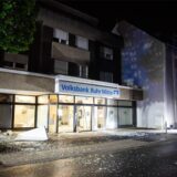 Außenansicht  der zerstörten Bankfiliale, vor der viele Glassplitter liegen.