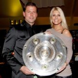 Roman Weidenfeller zusammen mit Lisa Weidenfeller und der Meisterschale.