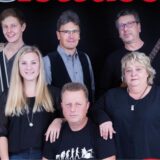 Das Gruppenbild zeigt zwei Frauen und vier Männer, von denen zwei eine Gitarre in den Händen halten.