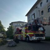 Ein Feuerwehrauto steht vor einem Wohnhaus.