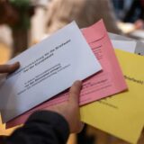 Eine Wählerin hält die Unterlagen zur Briefwahl für die Europawahl 2024 in den Händen.