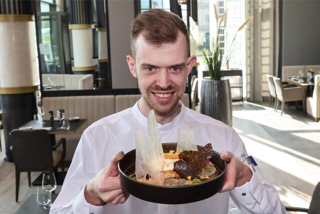 Eine Service-Kraft im Restaurant Haus Phönixsee in Dortmund präsentiert eine Speise.