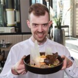 Eine Service-Kraft im Restaurant Haus Phönixsee in Dortmund präsentiert eine Speise.