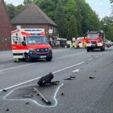 Trümmerteile auf der Fahrbahn mit Rettungsfahrzeugen im Hintergrund