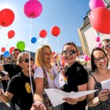 Menschen feiern mit Luftballons und Regenbogen-Flaggen auf dem Kirchplatz in Recklinghausen.