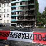 Trümmer liegen auf einer Straße in Düsseldorf vor einem Haus, in dem ein Brand wütete.