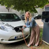Unsere freie Mitarbeiterin Vivien Caspers lädt ein Auto des Medienhauses Bauer an der Wallbox auf.