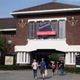 Menschen stehen vor dem Eingang des Designer Outlets in Roermond (Niederlande).