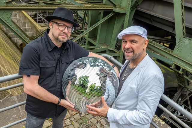 Heiko Taschke und Fanel Cornelius halten eine Discokugel.