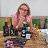Tina Hoffmann aus Recklinghausen sitzt hinter einer Riege von ausgefallenen Spirituosen aus ihrem Sortiment.