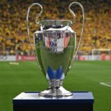 Mann wird der Hochzeitsring angelegt/ Champions-League-Pokal.