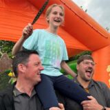 Die neue Kinderschützenkönigin auf den Schultern zweier Schützen
