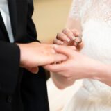 Ein Mann steckt seiner Frau einen Ring an den Finger.