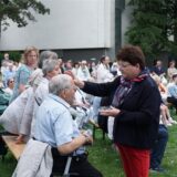 Menschen werden bei einem Open-Air-Gottesdienstes gesegnet.