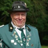 Ein Mann in Schützenuniform lächelt in die Kamera.